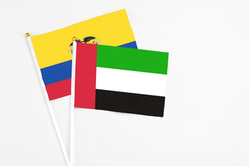 United Arab Emirates and Ecuador stick flags on white background. High quality fabric, miniature national flag. Peaceful global concept.White floor for copy space.