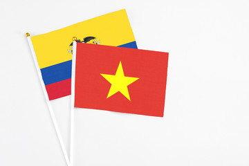Vietnam and Ecuador stick flags on white background. High quality fabric, miniature national flag. Peaceful global concept.White floor for copy space.