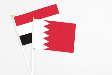 Bahrain and Egypt stick flags on white background. High quality fabric, miniature national flag. Peaceful global concept.White floor for copy space.