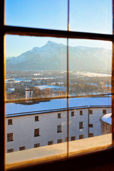 View from window glass on Salzburg of Austria in snow. Mozart city in Europe at winter. Travel at Alps. Cityscape, Panorama and landmark. Panoramic view on roofs of old Austrian town of Salzburgerland