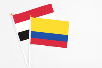 Colombia and Egypt stick flags on white background. High quality fabric, miniature national flag. Peaceful global concept.White floor for copy space.