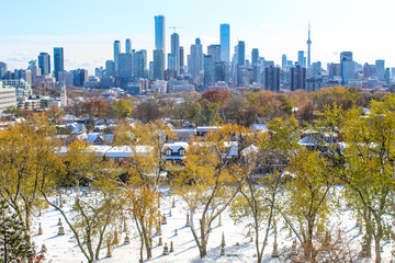 City skyline with view of cemetary, beautiful sunny day overlooking park and skyline, snow in autumn, winter in the city