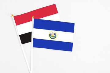 El Salvador and Egypt stick flags on white background. High quality fabric, miniature national flag. Peaceful global concept.White floor for copy space.