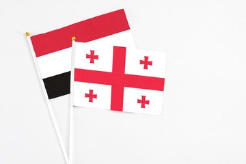 Obraz premium Georgia and Egypt stick flags on white background. High quality fabric, miniature national flag. Peaceful global concept.White floor for copy space.