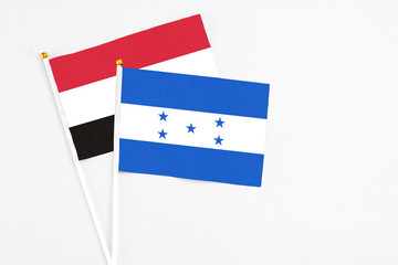 Honduras and Egypt stick flags on white background. High quality fabric, miniature national flag. Peaceful global concept.White floor for copy space.