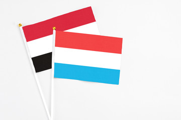 Luxembourg and Egypt stick flags on white background. High quality fabric, miniature national flag. Peaceful global concept.White floor for copy space.