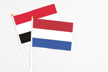Netherlands and Egypt stick flags on white background. High quality fabric, miniature national flag. Peaceful global concept.White floor for copy space.