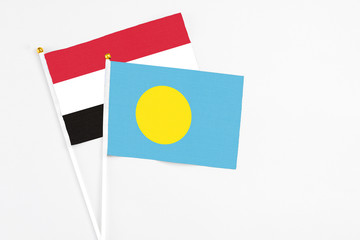 Palau and Egypt stick flags on white background. High quality fabric, miniature national flag. Peaceful global concept.White floor for copy space.