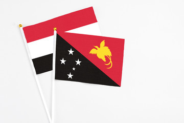 Papua New Guinea and Egypt stick flags on white background. High quality fabric, miniature national flag. Peaceful global concept.White floor for copy space.