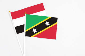 Saint Kitts And Nevis and Egypt stick flags on white background. High quality fabric, miniature national flag. Peaceful global concept.White floor for copy space.