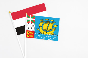 Saint Pierre And Miquelon and Egypt stick flags on white background. High quality fabric, miniature national flag. Peaceful global concept.White floor for copy space.