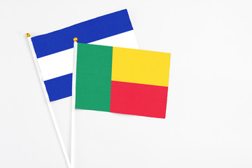 Benin and El Salvador stick flags on white background. High quality fabric, miniature national flag. Peaceful global concept.White floor for copy space.