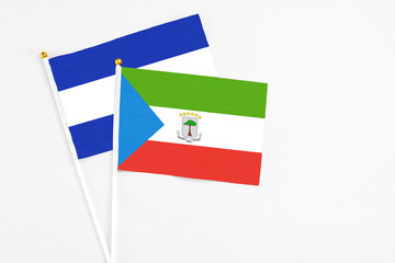 Equatorial Guinea and El Salvador stick flags on white background. High quality fabric, miniature national flag. Peaceful global concept.White floor for copy space.