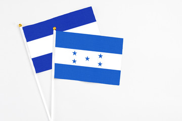 Honduras and El Salvador stick flags on white background. High quality fabric, miniature national flag. Peaceful global concept.White floor for copy space.