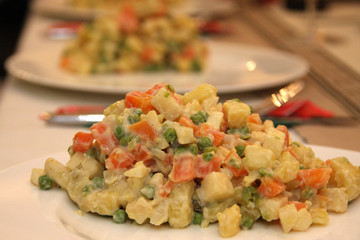 Russian salad on a white plate on a festive table