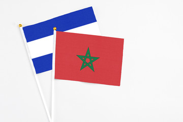 Morocco and El Salvador stick flags on white background. High quality fabric, miniature national flag. Peaceful global concept.White floor for copy space.