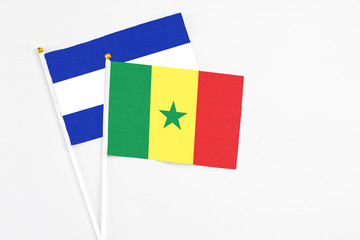 Senegal and El Salvador stick flags on white background. High quality fabric, miniature national flag. Peaceful global concept.White floor for copy space.