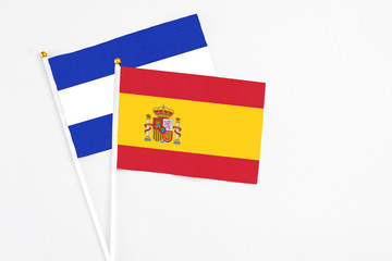 Spain and El Salvador stick flags on white background. High quality fabric, miniature national flag. Peaceful global concept.White floor for copy space.
