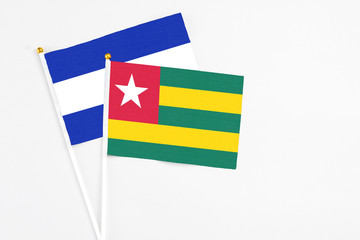Togo and El Salvador stick flags on white background. High quality fabric, miniature national flag. Peaceful global concept.White floor for copy space.