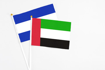 United Arab Emirates and El Salvador stick flags on white background. High quality fabric, miniature national flag. Peaceful global concept.White floor for copy space.