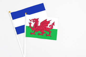 Wales and El Salvador stick flags on white background. High quality fabric, miniature national flag. Peaceful global concept.White floor for copy space.