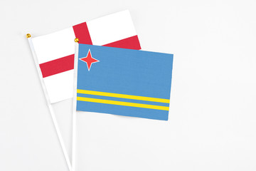 Aruba and England stick flags on white background. High quality fabric, miniature national flag. Peaceful global concept.White floor for copy space.
