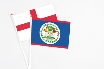 Belize and England stick flags on white background. High quality fabric, miniature national flag. Peaceful global concept.White floor for copy space.