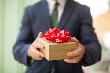 Unrecognizable  businessman holding a present.