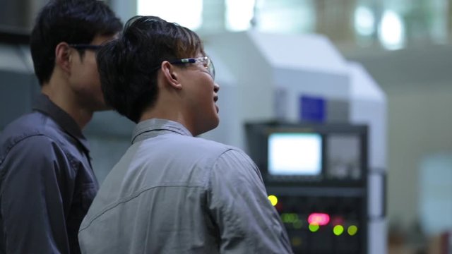Young Chinese engineers inspecting in factory,HD