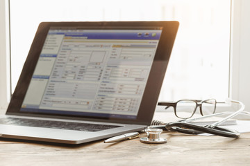 Obraz premium Medical consultation online concept. Laptop with stethoscope and document