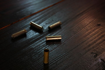 blank iron bullets on retro wood in low light ,dark or underground illegal concept.