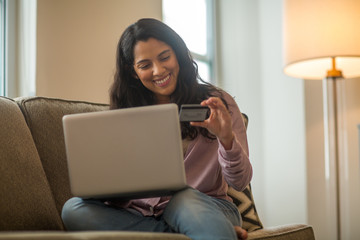 Hispanic woman at home shopping online.