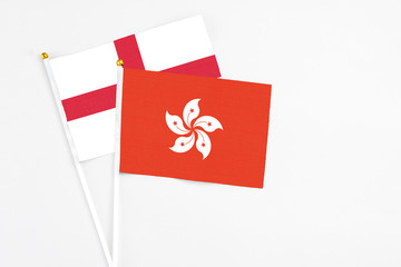 Hong Kong and England stick flags on white background. High quality fabric, miniature national flag. Peaceful global concept.White floor for copy space.