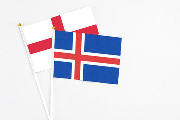Obraz premium Iceland and England stick flags on white background. High quality fabric, miniature national flag. Peaceful global concept.White floor for copy space.