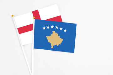 Kosovo and England stick flags on white background. High quality fabric, miniature national flag. Peaceful global concept.White floor for copy space.