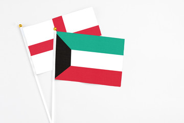 Kuwait and England stick flags on white background. High quality fabric, miniature national flag. Peaceful global concept.White floor for copy space.