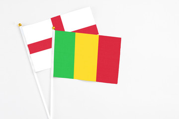 Mali and England stick flags on white background. High quality fabric, miniature national flag. Peaceful global concept.White floor for copy space.