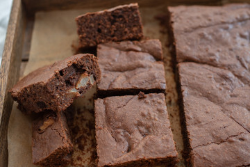 Homemade chocolate brownies on a white plate on a white wooden background