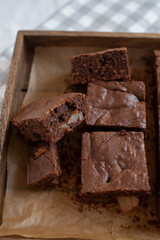 Homemade chocolate brownies on a white plate on a white wooden background