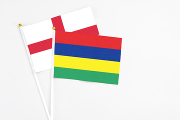 Mauritius and England stick flags on white background. High quality fabric, miniature national flag. Peaceful global concept.White floor for copy space.