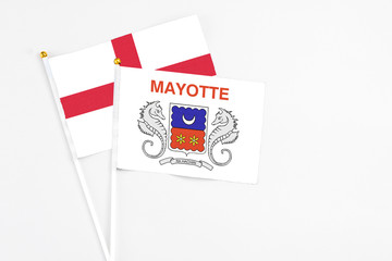 Mayotte and England stick flags on white background. High quality fabric, miniature national flag. Peaceful global concept.White floor for copy space.