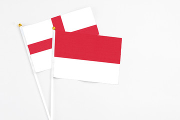 Monaco and England stick flags on white background. High quality fabric, miniature national flag. Peaceful global concept.White floor for copy space.
