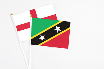 Saint Kitts And Nevis and England stick flags on white background. High quality fabric, miniature national flag. Peaceful global concept.White floor for copy space.