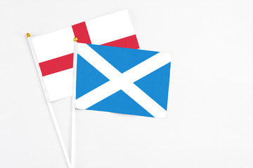 Scotland and England stick flags on white background. High quality fabric, miniature national flag. Peaceful global concept.White floor for copy space.