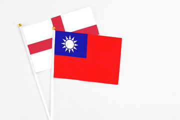 Taiwan and England stick flags on white background. High quality fabric, miniature national flag. Peaceful global concept.White floor for copy space.