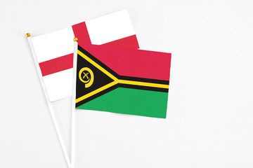 Vanuatu and England stick flags on white background. High quality fabric, miniature national flag. Peaceful global concept.White floor for copy space.