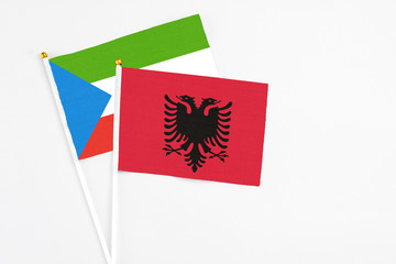Albania and Equatorial Guinea stick flags on white background. High quality fabric, miniature national flag. Peaceful global concept.White floor for copy space.