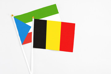 Belgium and Equatorial Guinea stick flags on white background. High quality fabric, miniature national flag. Peaceful global concept.White floor for copy space.