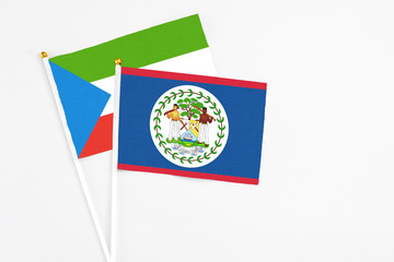 Belize and Equatorial Guinea stick flags on white background. High quality fabric, miniature national flag. Peaceful global concept.White floor for copy space.
