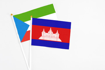 Cambodia and Equatorial Guinea stick flags on white background. High quality fabric, miniature national flag. Peaceful global concept.White floor for copy space.